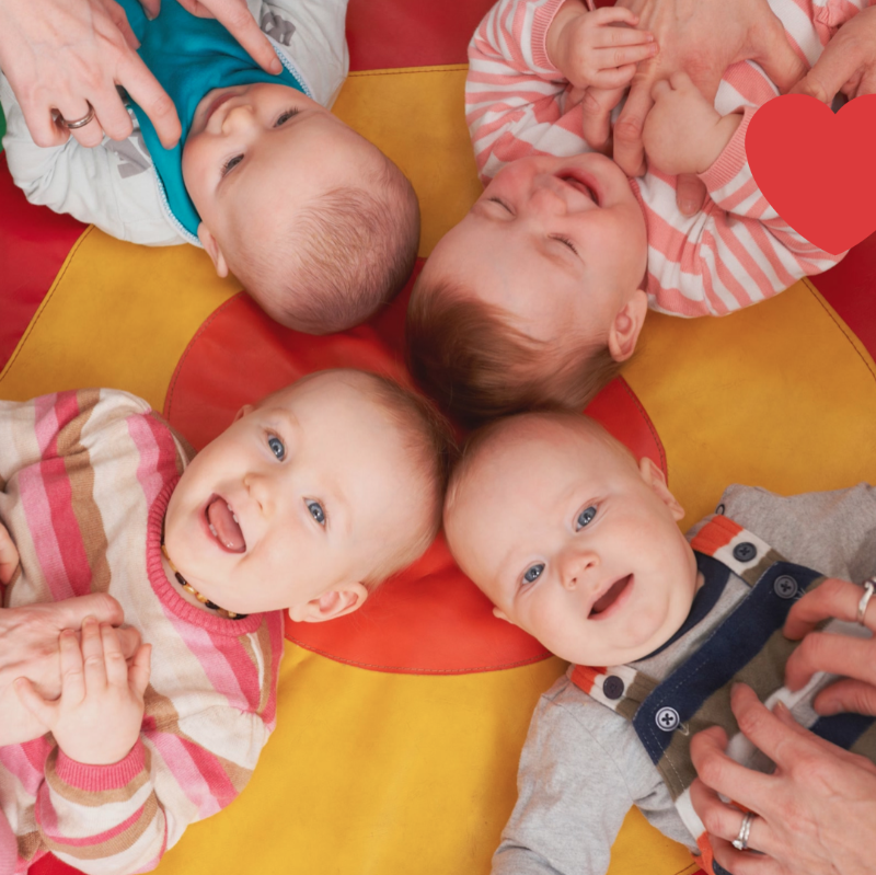 Kinder liegen im Kreis auf dem Boden